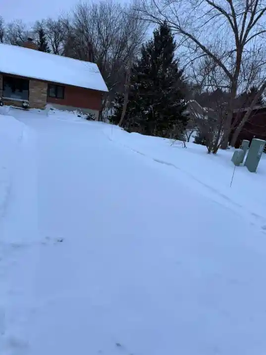 Driveway covered in deep snow before clearing